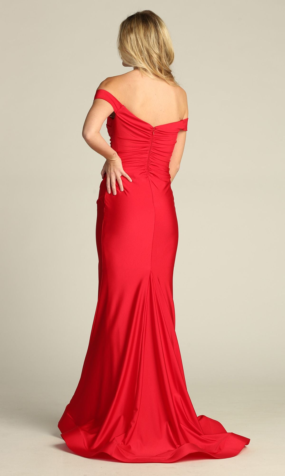 A woman facing away in the Chicas YG5025 Off-the-Shoulder Long Prom Dress—a floor-length, fitted red gown with a slight train—radiates timeless elegance.